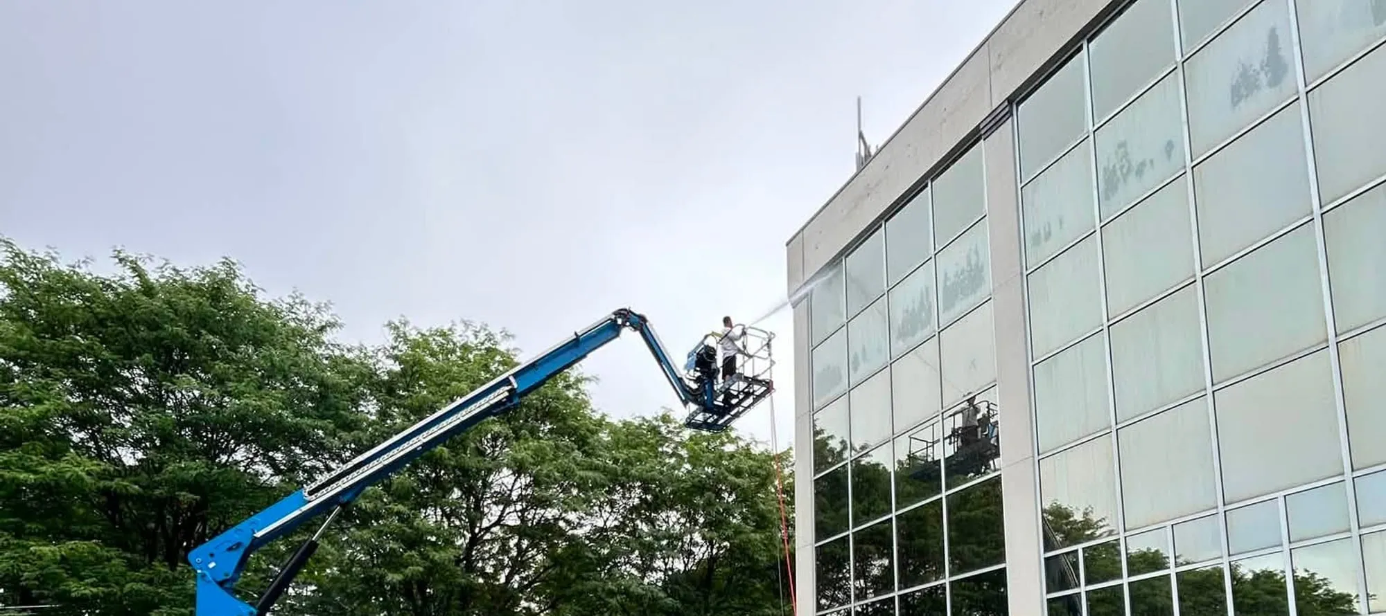 Wash Works crew cleaning the glass facade of a Vermont office building from a boom lift