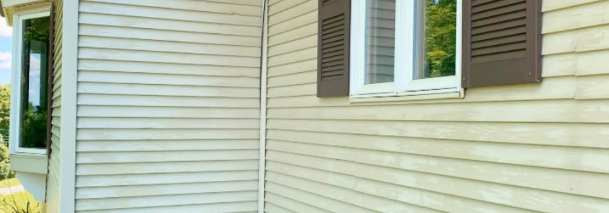 Clean cream siding and white trim on a Vermont home after a soft wash